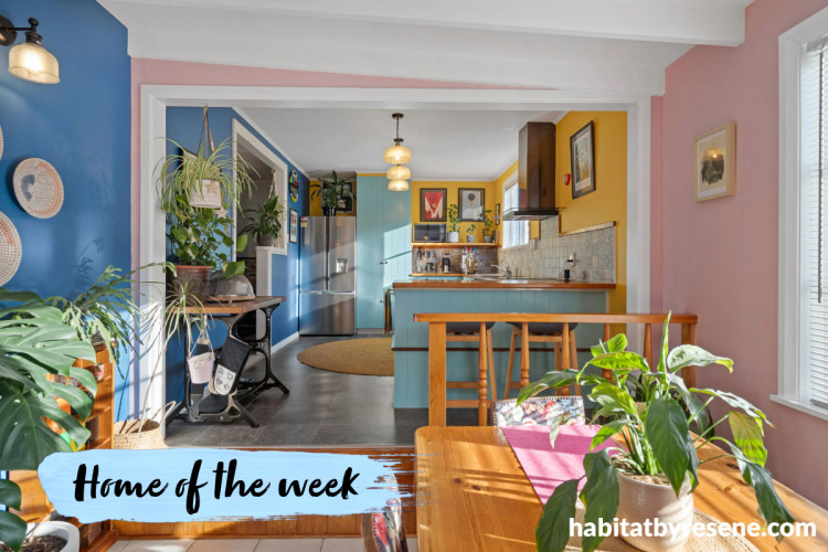 Dining area with soft pink walls and kitchen with bright yellow walls and soft blue cabinets