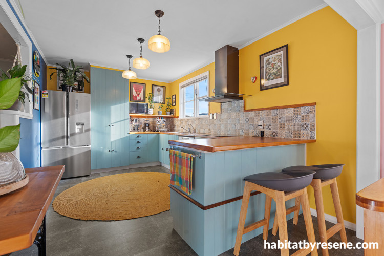 Kitchen featuring bright yellow walls and soft blue cabinets
