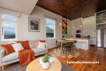 Kitchen and dining area with Resene Colorwood Dark Rimu ceiling walls and trims painted in Resene Milk White.