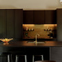 Kitchen featuring neutral walls and black kitchen cabinets