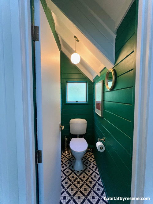 Toilet featuring dark green walls
