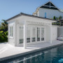 White pool house exterior painted in Resene Wan White with cladding in Resene Foggy Grey