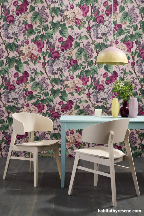 A dining room with floral wall paper