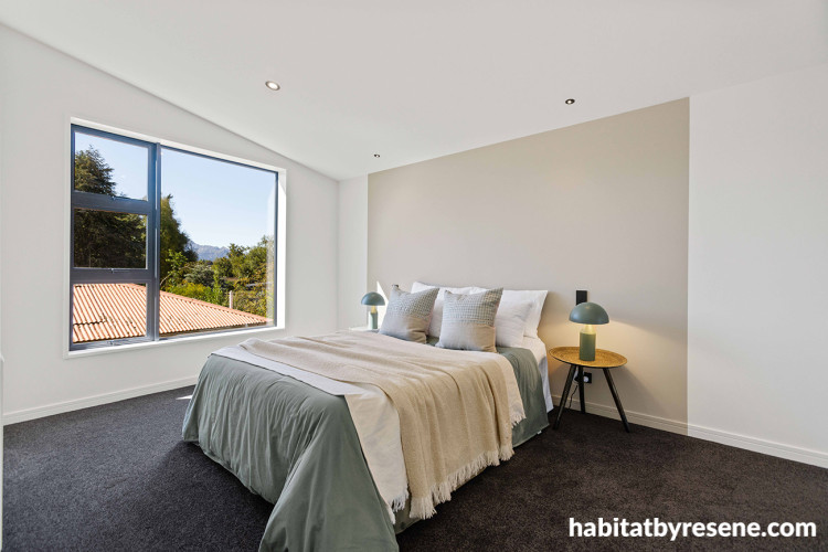 Bedroom featuring neutral-toned walls and painted headboard